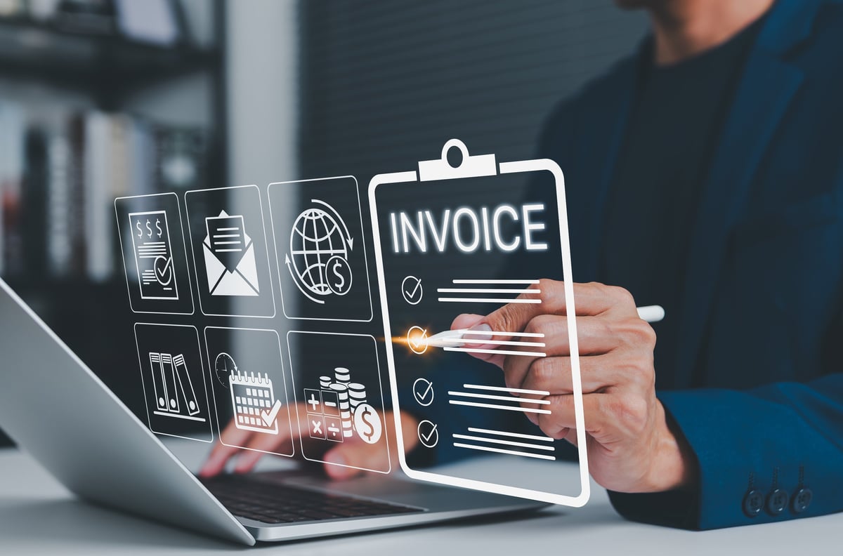Small business owner reviewing bookkeeping invoices on a laptop